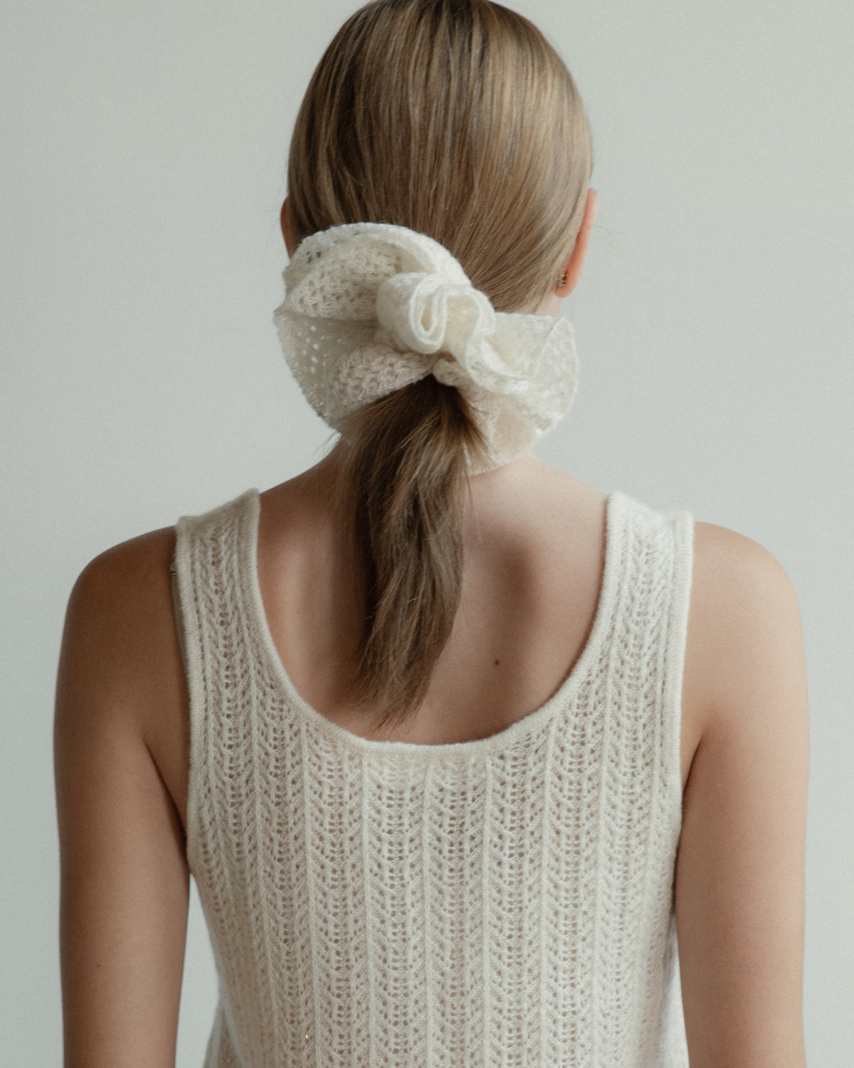 Cream coloured cashmere laceknit scrunchie and tank top worn by a model.